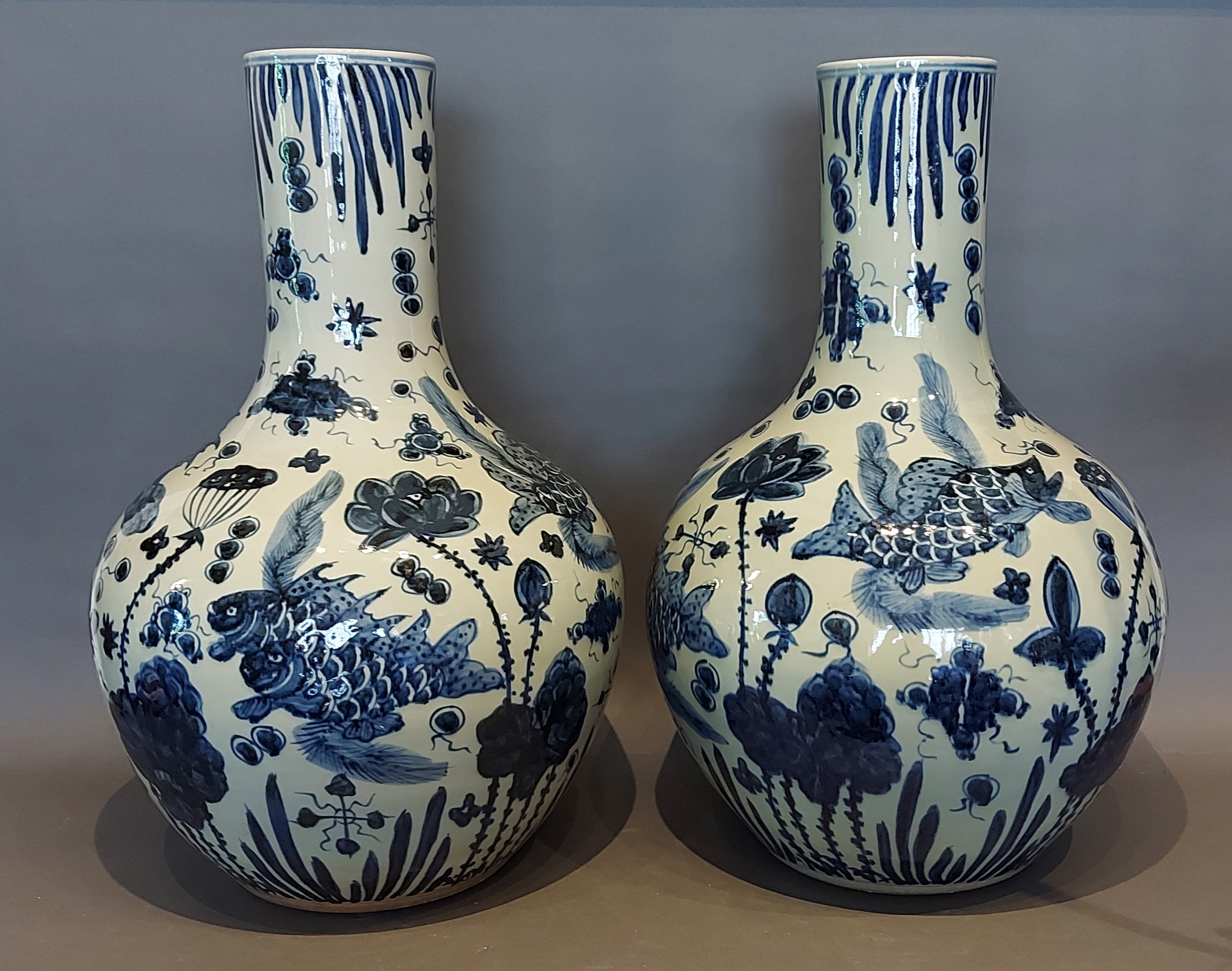 A pair of Chinese underglaze blue decorated bottle neck large vases each decorated with carp amongst