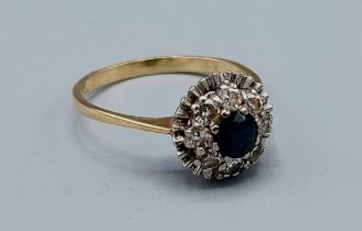 An 18ct gold Sapphire and Diamond cluster ring set with a central Sapphire surrounded by Diamonds,