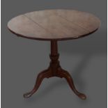 A George III oak pedestal table, the circular top above a turned centre column with pad feet,