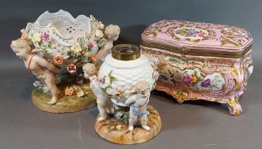 A German porcelain lamp base in the form of a basket held by three Putti together with a similar
