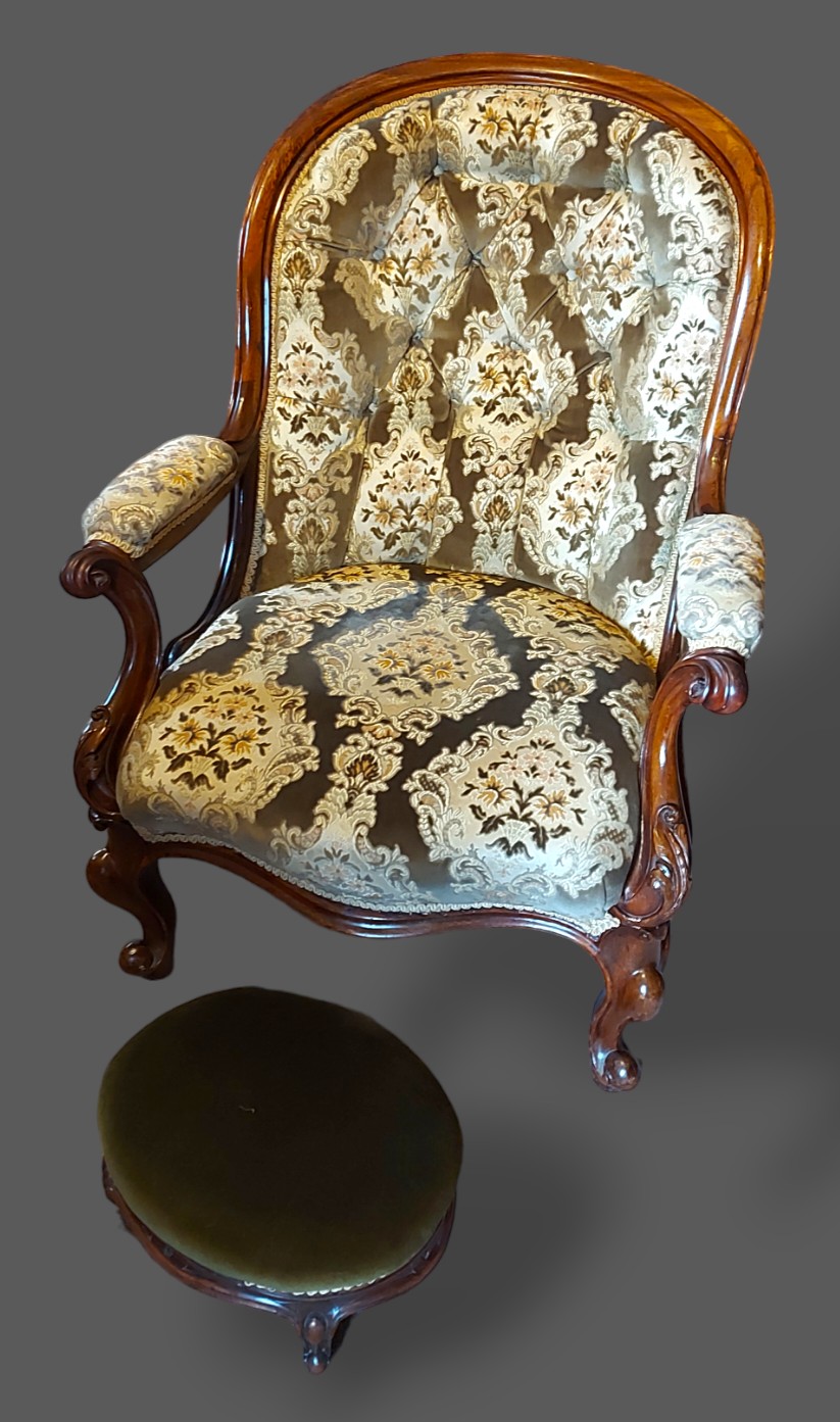 A Victorian mahogany drawing room armchair with a button upholstered back above an overstuffed