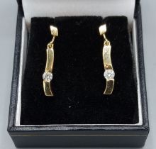 A pair of 18ct gold drop earrings each set with a Diamond, 2.7gms, 2.4cms long