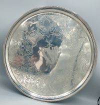 A George III silver salver of circular form with central engraved crest within an engraved border,
