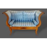 A 19th Century French boudoir sofa with shaped scroll ends above an inlaid frieze raised upon