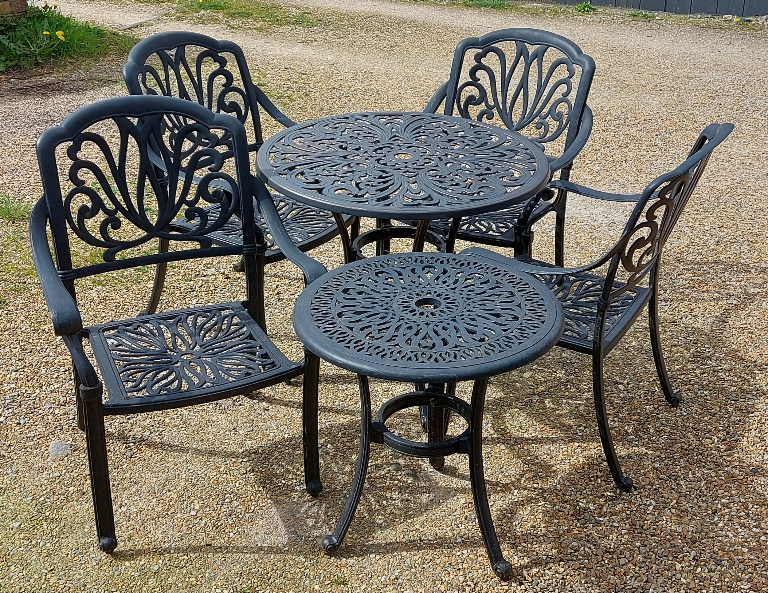 An aluminium garden table together with a set of four matching chairs and another smaller garden