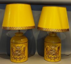 A pair of Toleware table lamps, each decorated with a crest upon a mustard ground, complete with