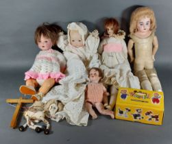 An Armand Marseille bisque head doll together with four other dolls and a Pelham puppet