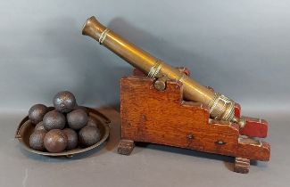 A 19th Century bronze signal cannon with later stand together with a collection of cannon balls