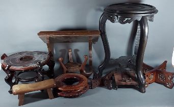 A Chinese vase stand together with various other stands and a clock bracket