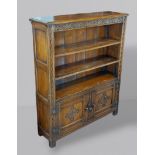 An oak bookcase with open shelves above two doors flanked by stiles, 95cms wide, 28cms deep and