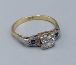 An 18ct white gold ring set with a central Diamond flanked by sapphires, 2.7gms, ring size O