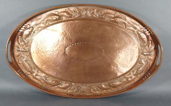 A Newlyn Arts and Crafts copper tray of oval form embossed with fish, 54cms x 34.5cms