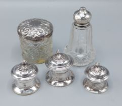 A group of three Indian white metal canisters together with two silver and glass dressing table