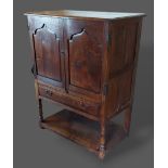An 18th Century style oak side cabinet, the moulded top above a pair of panel doors and fall front