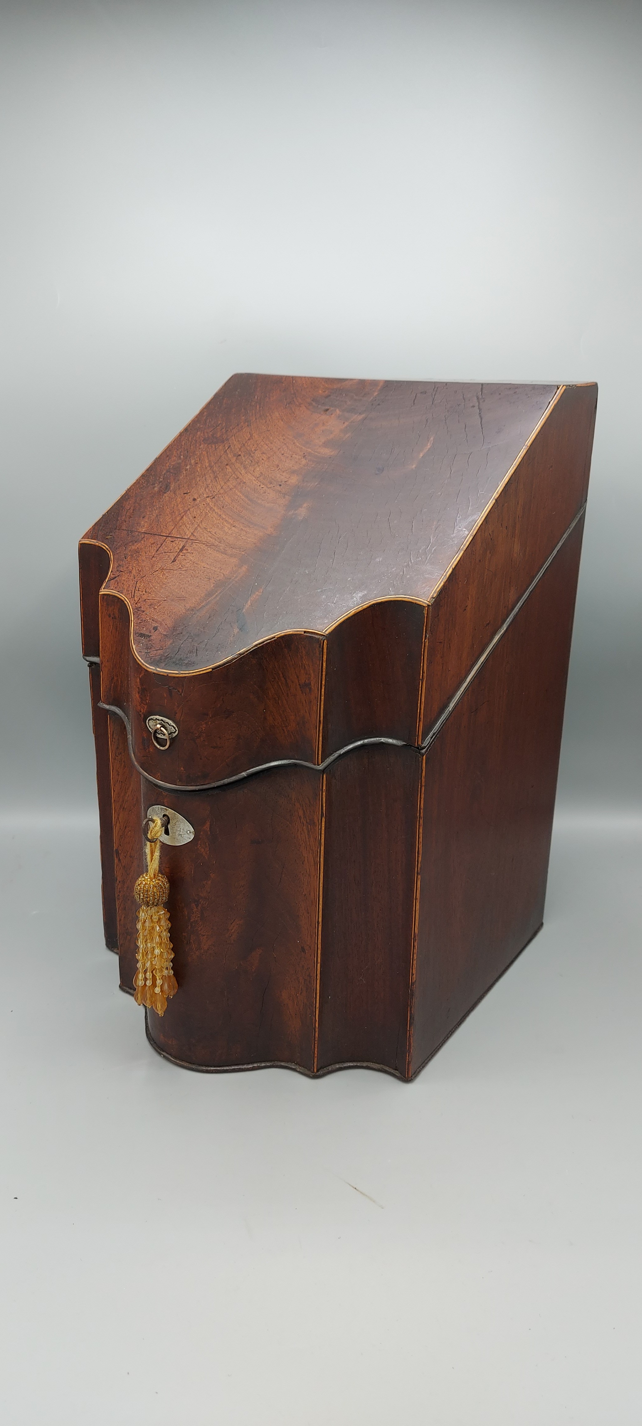 A Regency mahogany serpentine knife box, interior missing, 36cms tall