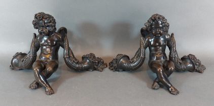 A pair of French patinated bronze models of Putti, 14cms tall