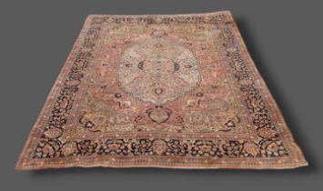 A Kerman carpet with a central medallion within an all-over design upon a cream and blue ground