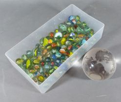 A collection of glass marbles together with a glass paperweight in the form of a globe