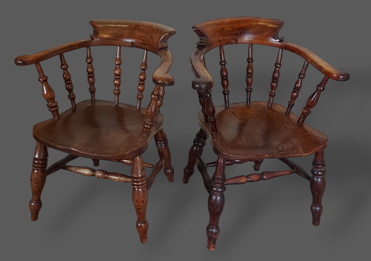 A near pair of 19th Century Captains armchairs, each with a shaped spindle turned back above a panel