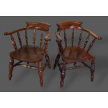 A near pair of 19th Century Captains armchairs, each with a shaped spindle turned back above a panel