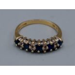 An 18ct gold band ring set with Diamonds and Sapphires, claw set, 3.9gms, ring size O
