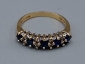 An 18ct gold band ring set with Diamonds and Sapphires, claw set, 3.9gms, ring size O
