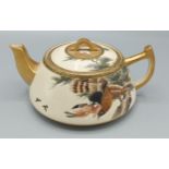 A Satsuma earthenware teapot decorated with birds amongst foliage highlighted with gilt