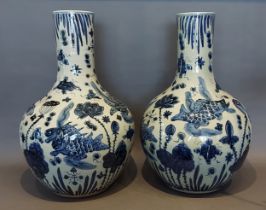 A pair of Chinese underglaze blue decorated bottle neck large vases each decorated with carp amongst