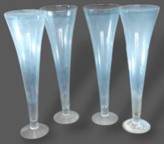 A set of four large glass table centrepiece vases of tapering form, 80cms tall