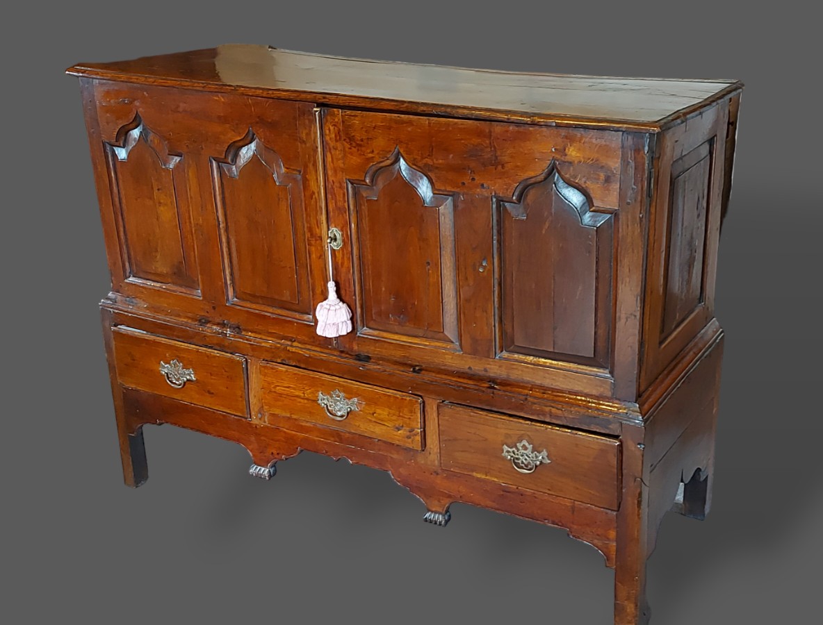 A George III oak mule chest, the moulded top above above two panel doors and three drawers with
