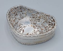 An Edwardian silver box of shaped form, the pierced hinged cover decorated with a figure amongst