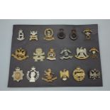 A collection of eighteen British Army Regimental cap badges to include Royal Scots Tank Corp