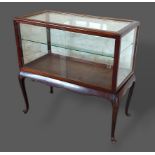 An Edwardian Bijouterie, the glazed top above a shaped frieze raised upon cabriole legs, 91cms wide,
