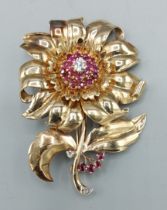 A 9ct gold large brooch in the form of a flower head set with a central Diamond and surrounded by