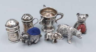 A silver small pin cushion in the form of a pig together with another pin cushion, two ssmall models