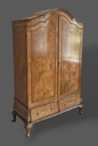 A Circa 1920's walnut Queen Anne style wardrobe, with a shaped cornice above two doors with two