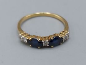 An 18ct gold Sapphire and Diamond band ring set with two Sapphire and five Diamonds, 2.8gms, ring
