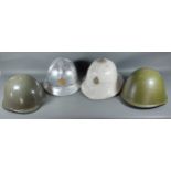 A Yugoslavian firemans helmet together with two military helmets and a Pith helmet