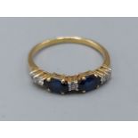 An 18ct gold Sapphire and Diamond band ring set with two Sapphire and five Diamonds, 2.8gms, ring