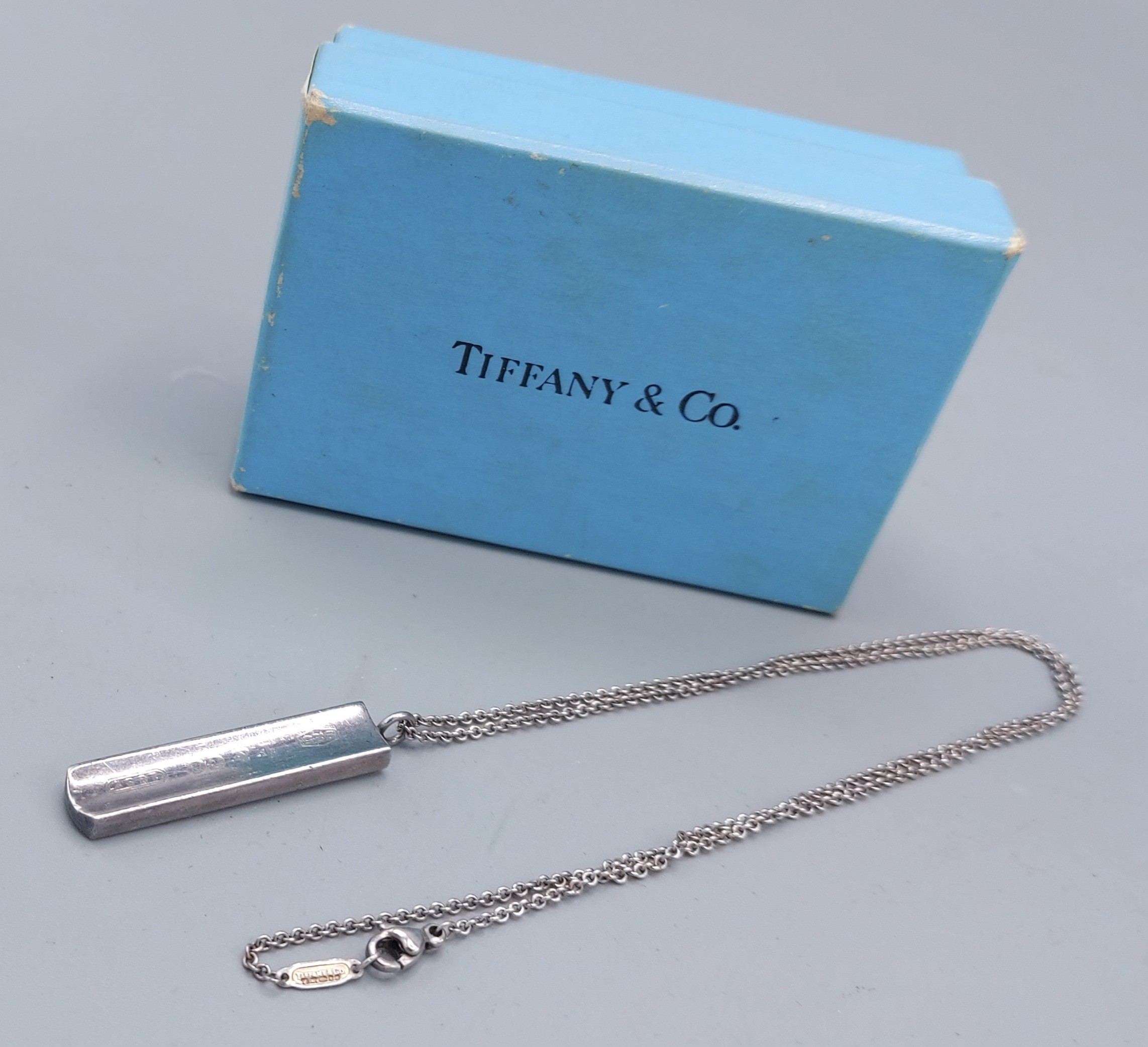 Tiffany and Co. a Sterling silver pendant of shaped ingot form with matching linked chain complete