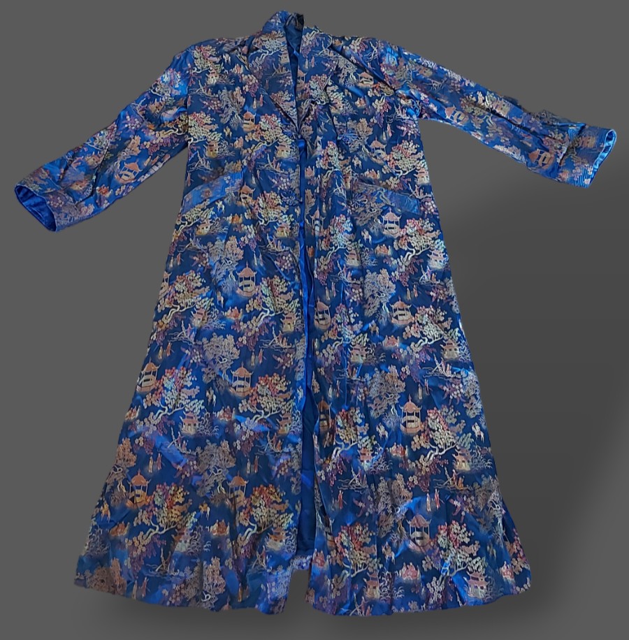 A Chinese Kimono embroidered with figures amongst foliage with blue ground