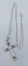 A Sterling silver crucifix pendant set with green stones together with a linked chain