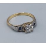 An 18ct white gold ring set with a central Diamond flanked by sapphires, 2.7gms, ring size O