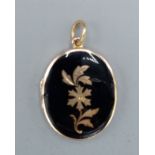 An 18ct gold and enamel locket of oval form with suspension ring, 11.1gms, 3cms x 2.5cms