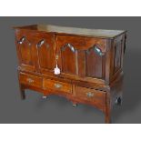 A George III oak mule chest, the moulded top above above two panel doors and three drawers with