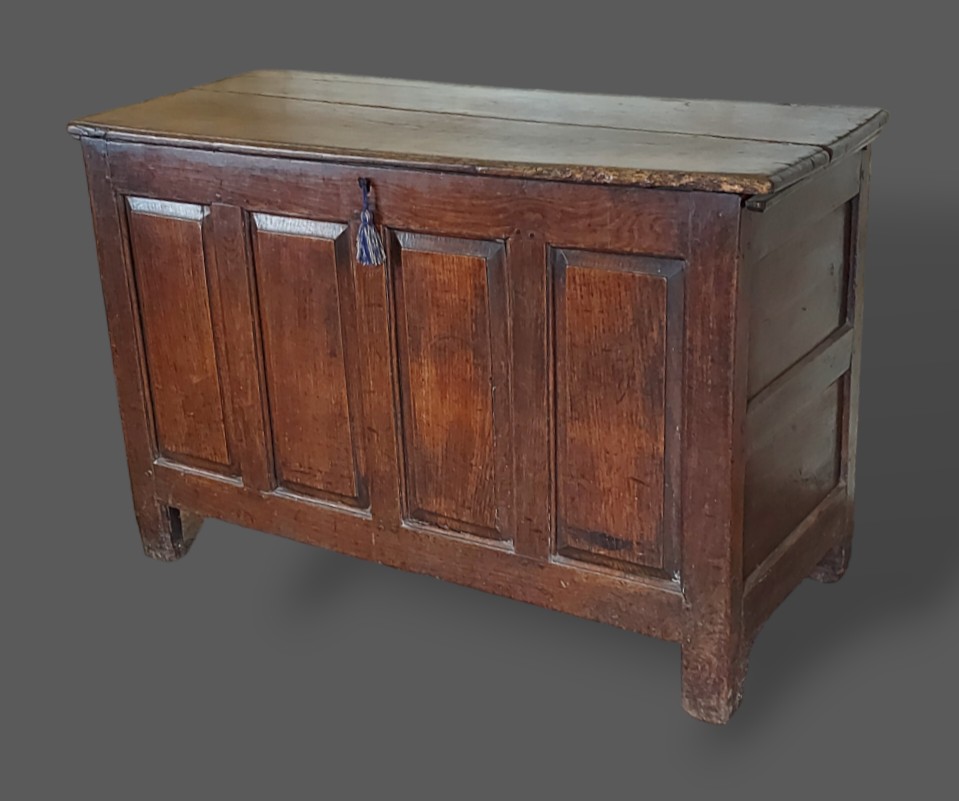 A George III oak coffer with a four panel front flanked by stiles, 128cms wide, 52cms deep and 83cms