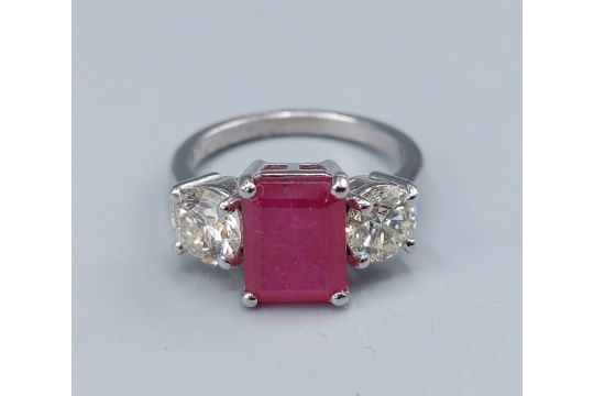 A Platinum three stone ring set with a central recangular Ruby flanked by Diamonds, claw set, 5.