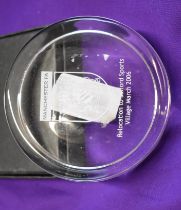 A glass paperweight inscribed "Manchester FA Relocation to Salford Sports Village March 2006" with