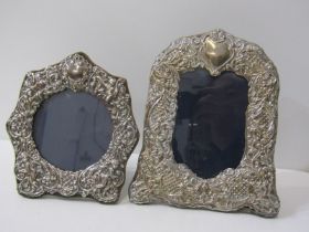 TWO ORNATE SILVER PHOTO FRAMES, one with embossed putti figure surround, 17cm height