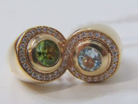 14ct YELLOW GOLD PERIDOT AND AQUAMARINE CROSSOVER RING, unusual figure 8 design set with an